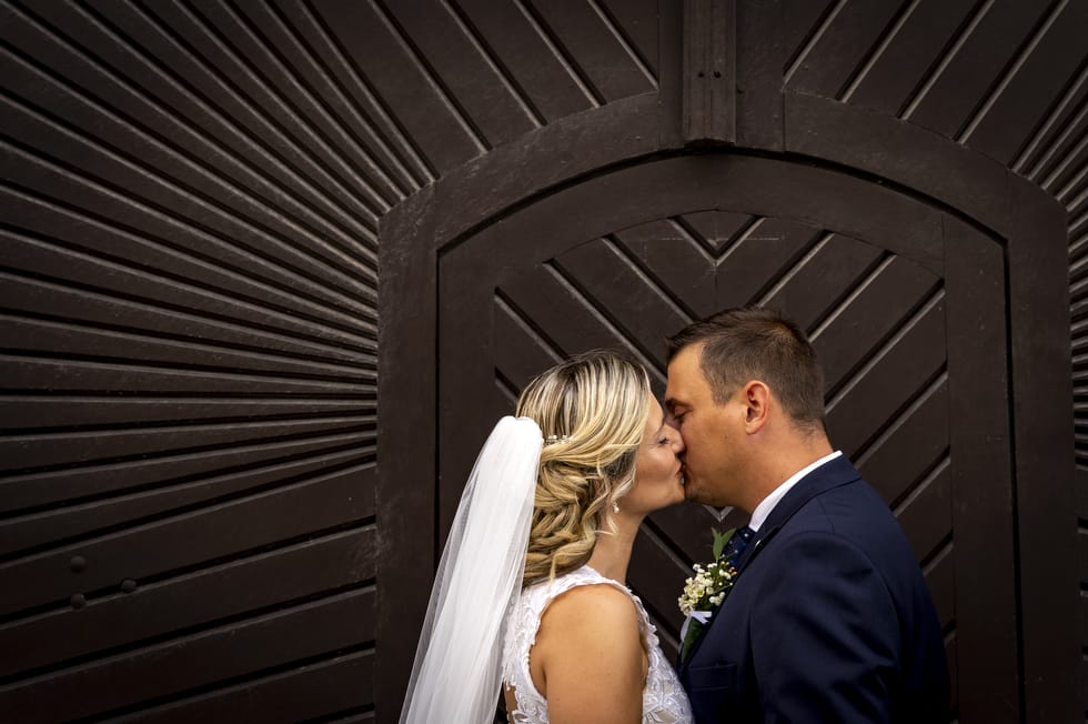 Friss házaspár esküvői kreatív fotózás közben a veszprémi vár egyik kapualjában