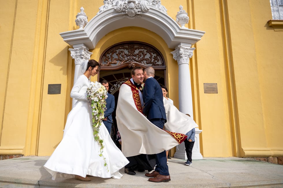 Református lelkész gratulál az ifjú házaspárnak a templomi szertartás után.